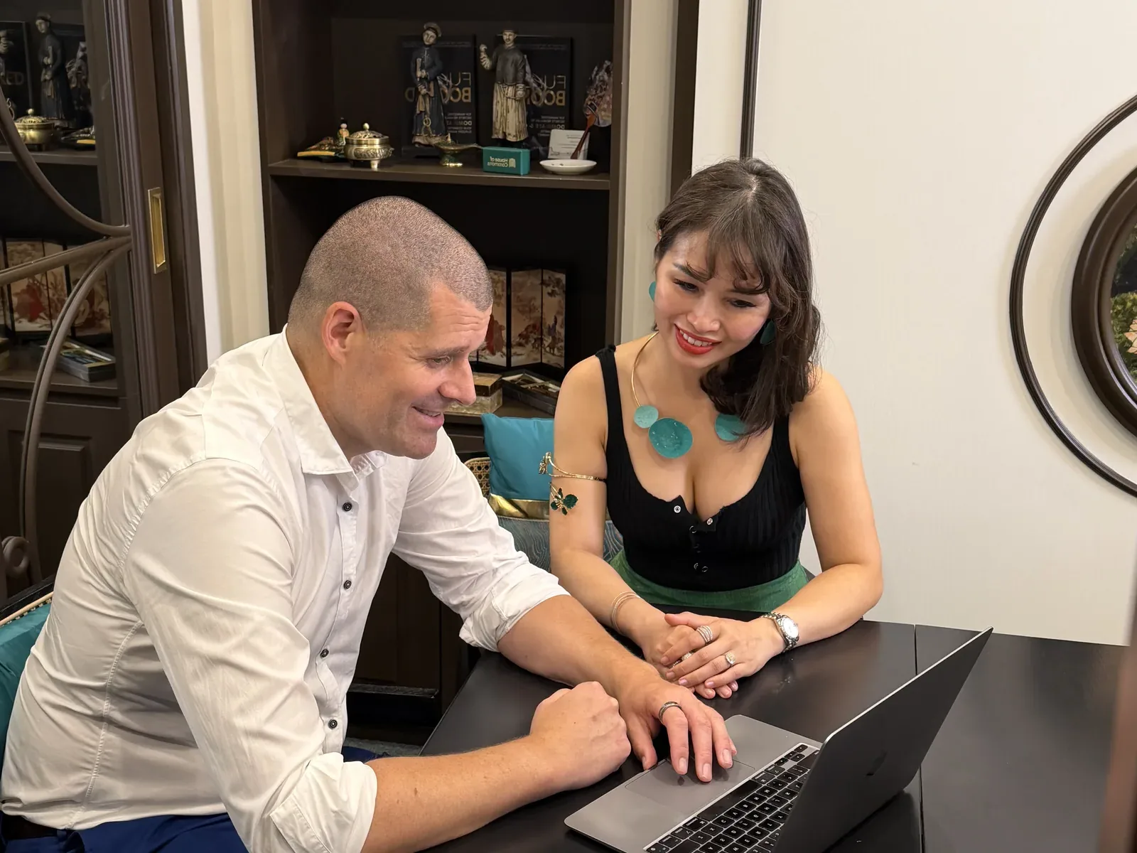 Two of the team going through a plan on a laptop